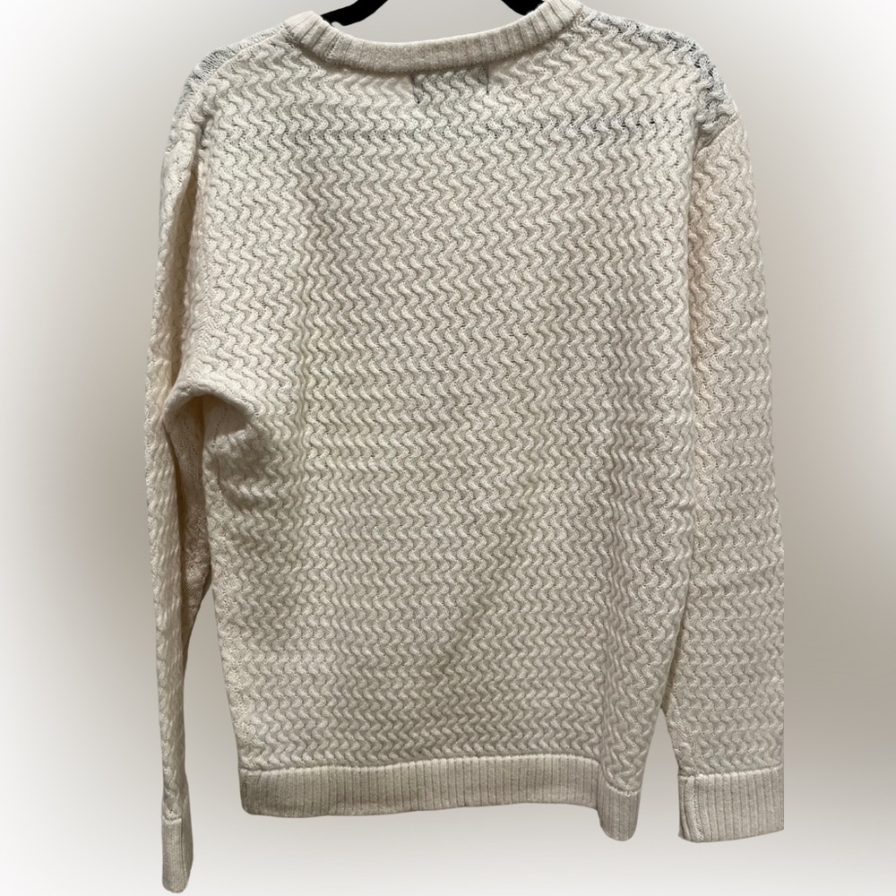 Textured wool crewneck sweater. Features a slightly oversized fit. Cream.